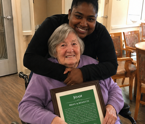Woman holding a personalized name meaning print received as a retirement gift
